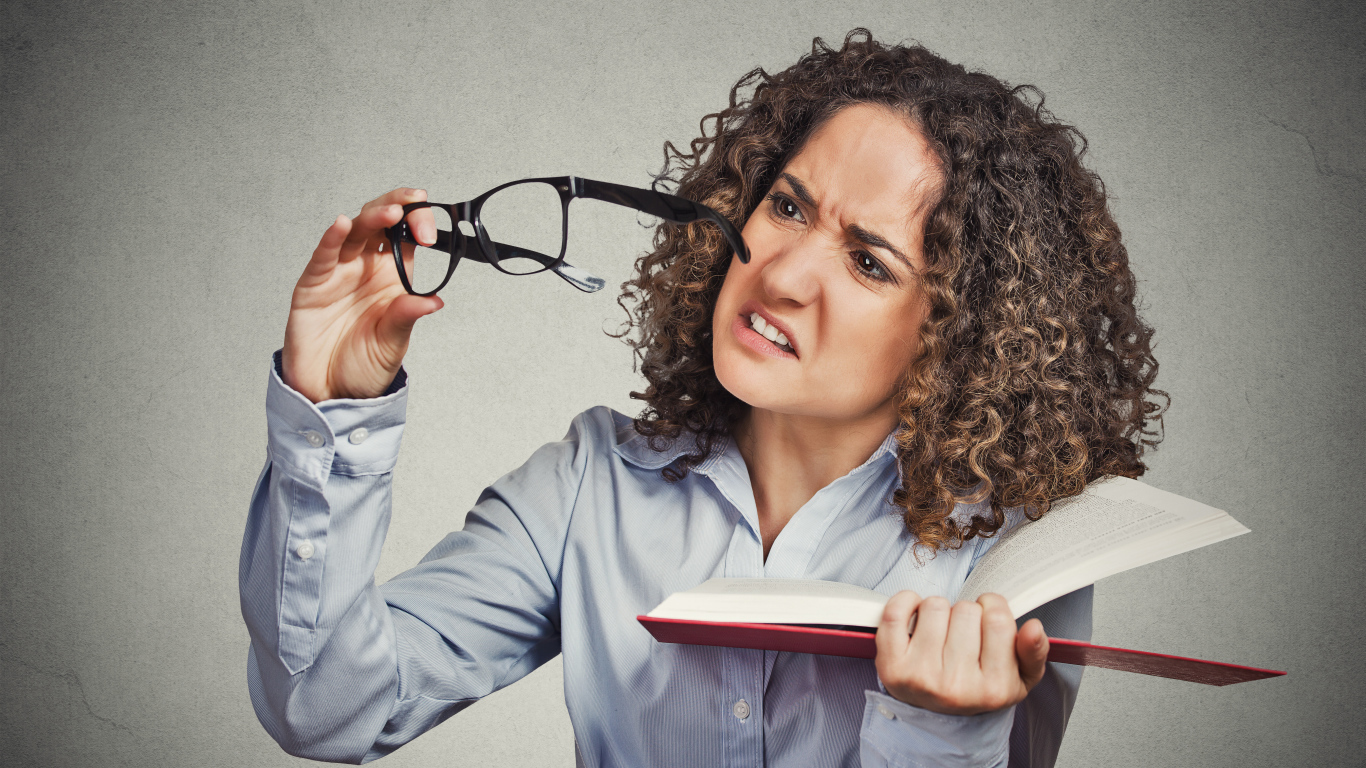 Девушка с книгой с очками в руке