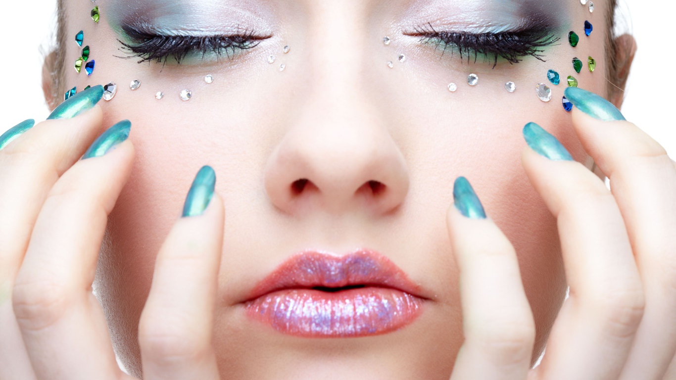 Девушка  с ярким макияжем и стразами на лице 