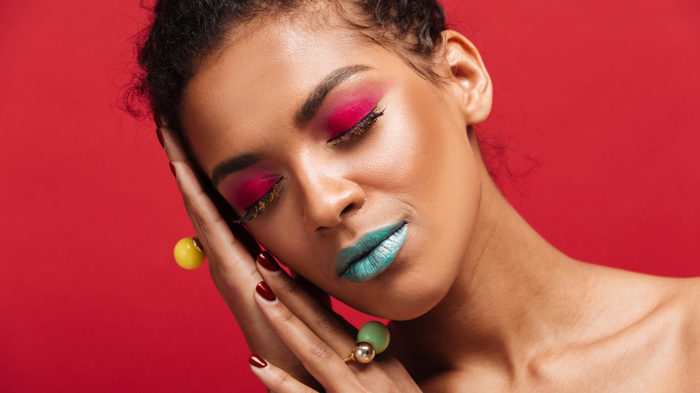 Девушка с ярким макияжем на красном фоне