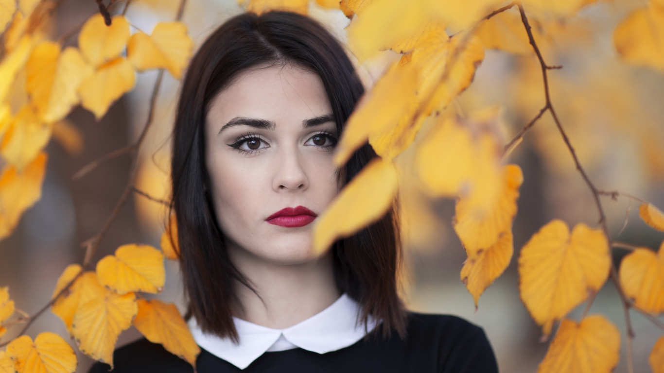 Девушка с красными губами у ветки с желтыми листьями
