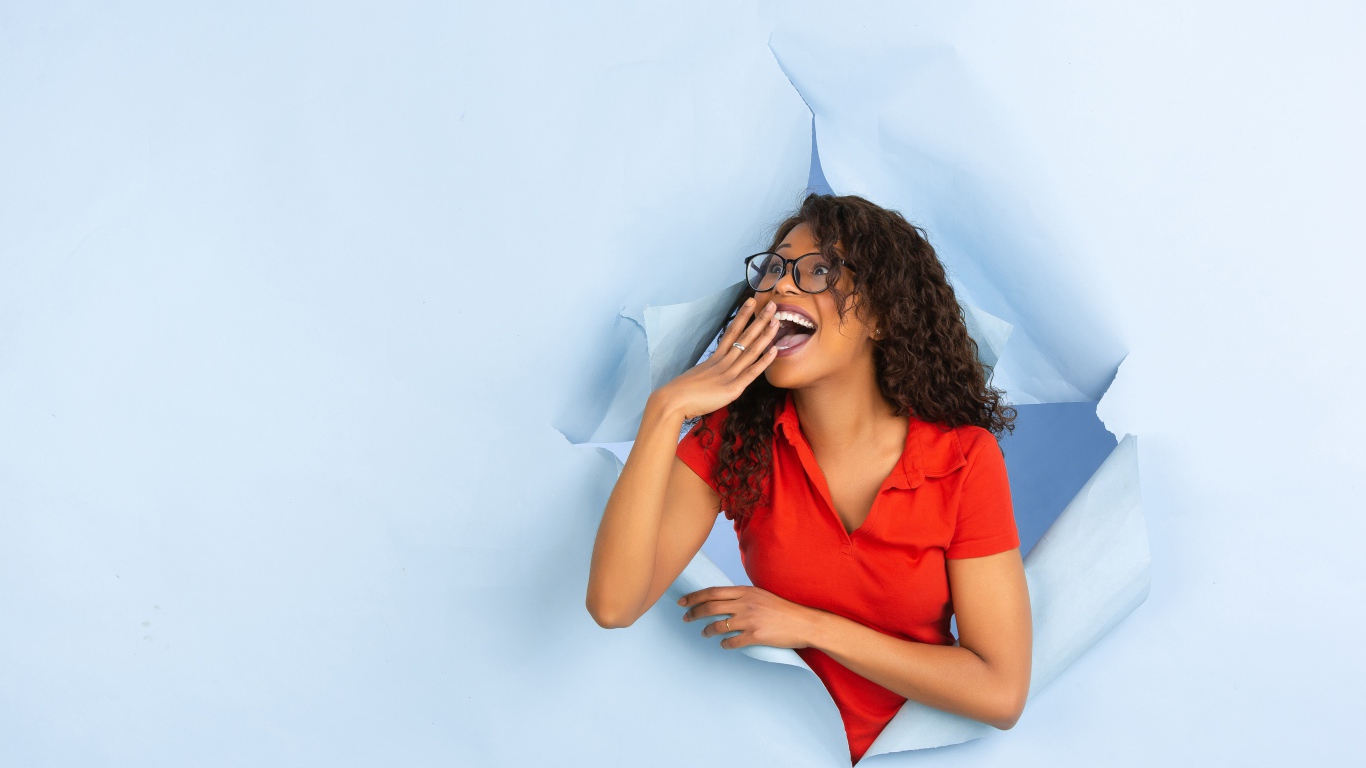 Радостная девушка прорвала дыру в стене