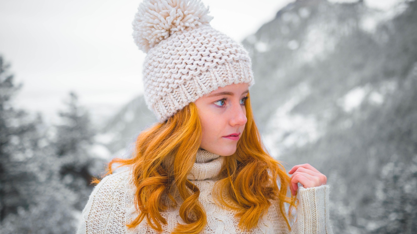 Рыжеволосая девушка в теплой шапке зимой 