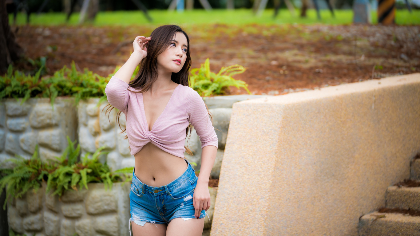 Стройная девушка азиатка в шортах стоит у ступенек