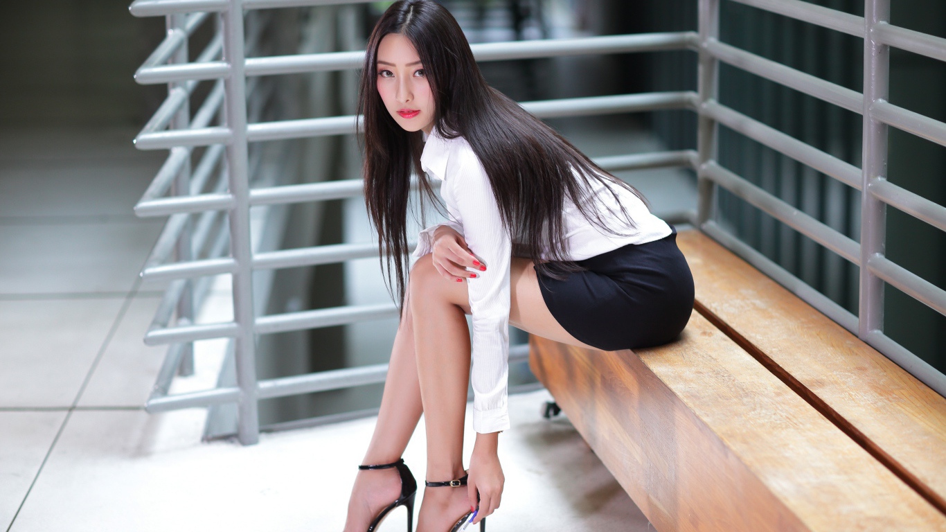 Стильная деловая девушка азиатка сидит  на лавке