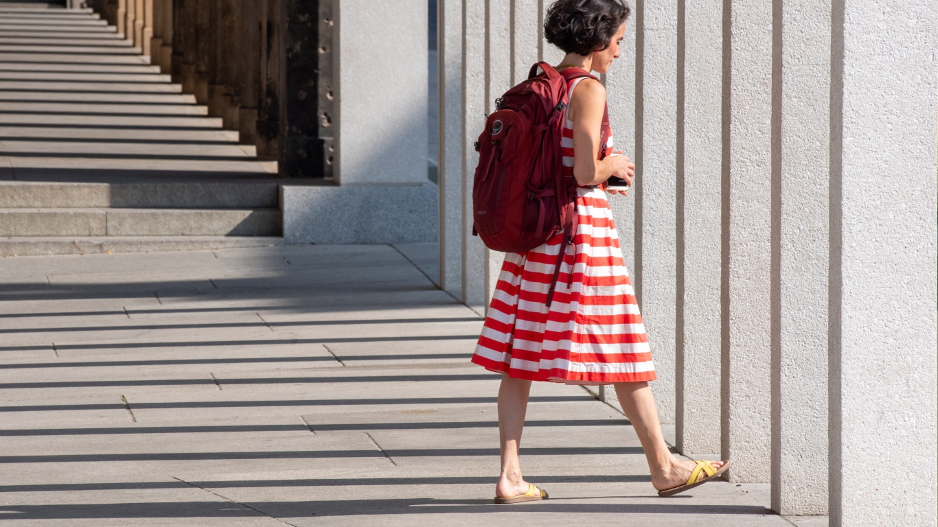Женщина в красном полосатом платье с рюкзаком