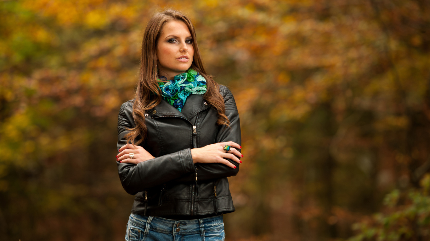 Молодая девушка в черной кожаной куртке  в парке