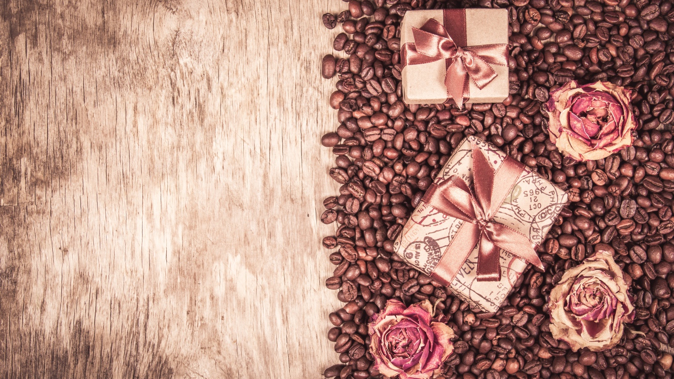 Подарки и розы лежат на кофейных зернах
