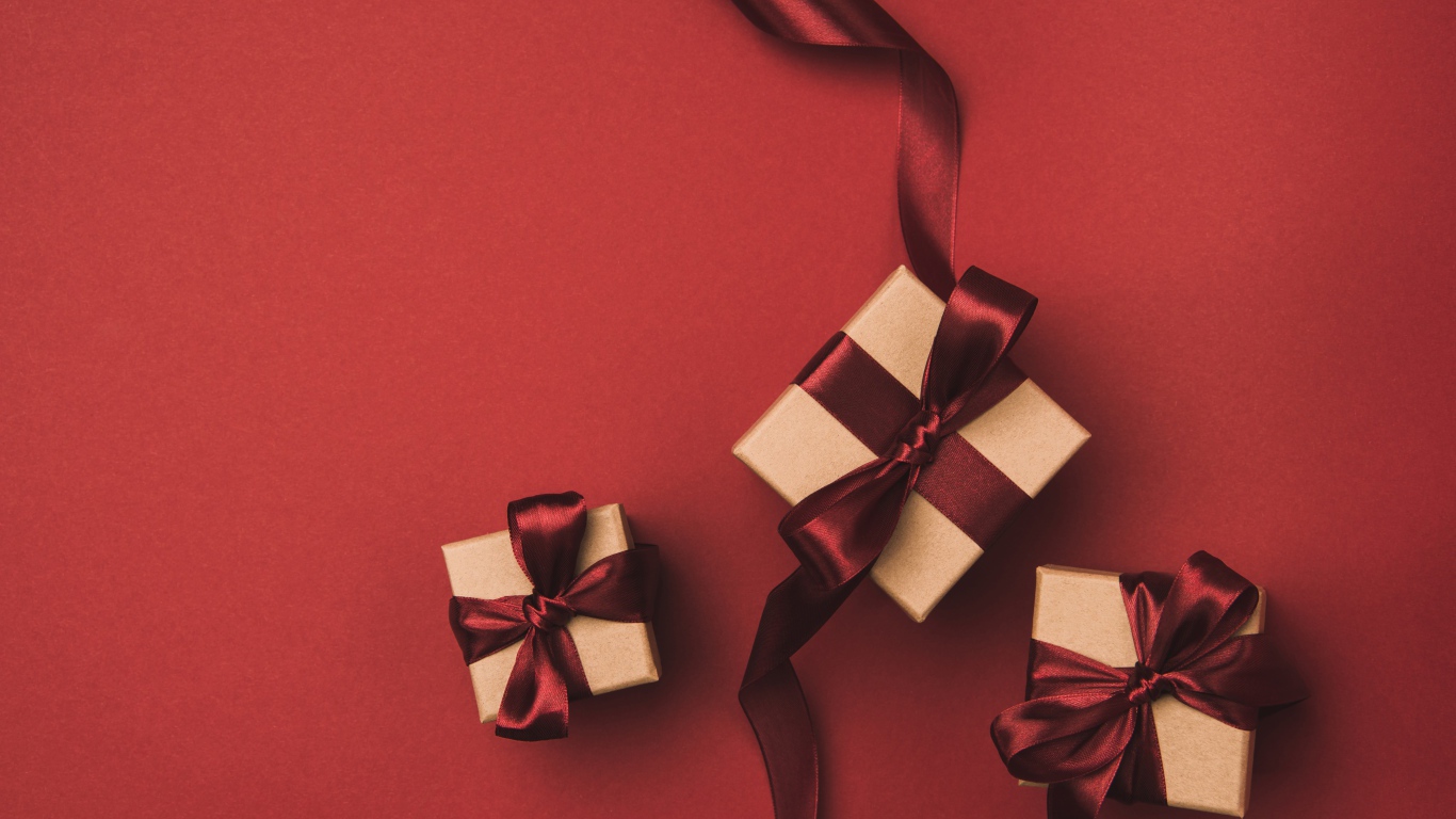 Three gift boxes with bows on a red background.