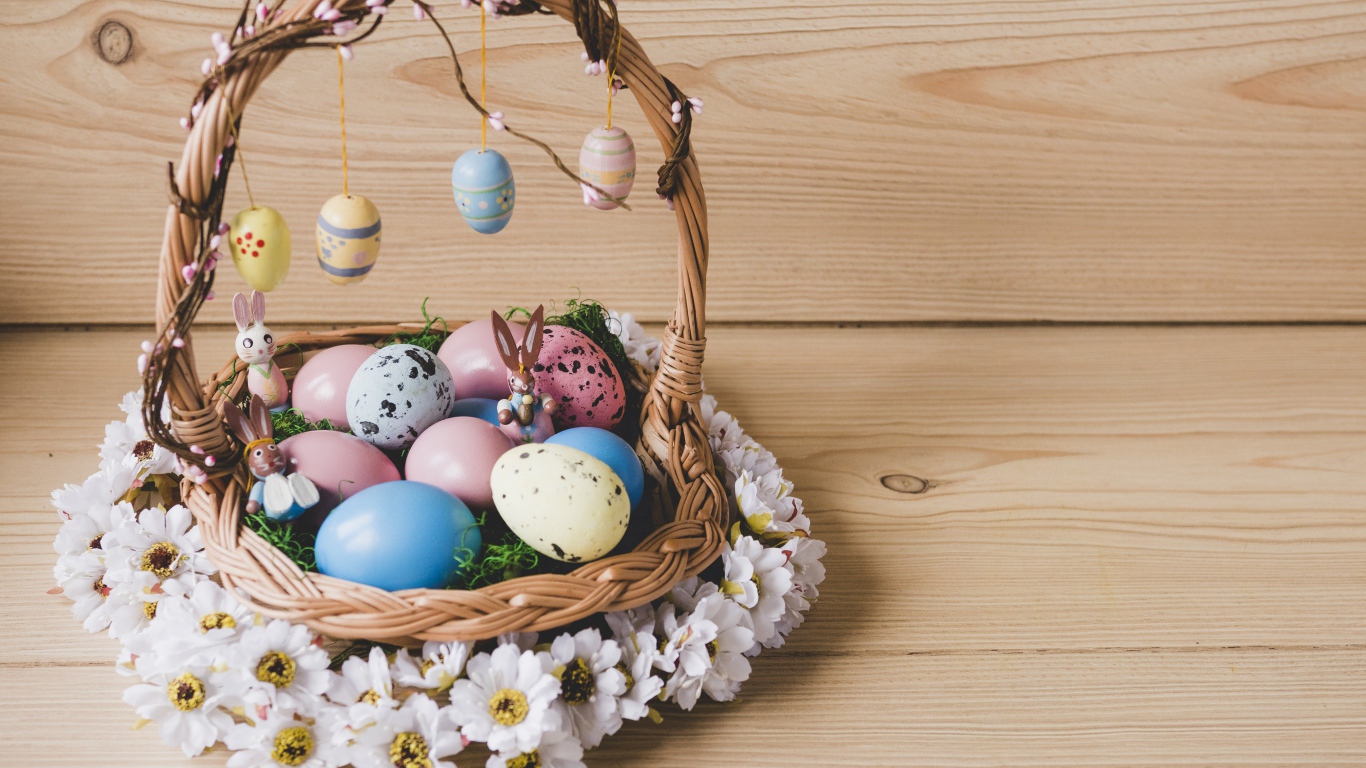 Корзинка с пасхальными яйцами украшена цветами