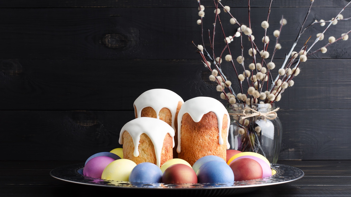 Вкусные куличи на подносе с яйцами и ветками вербы на Пасху