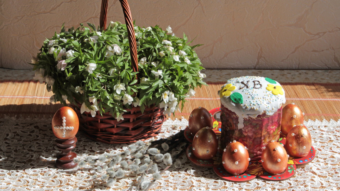 Пасхальный кулич с яйцами на столе с корзинкой цветов на праздник