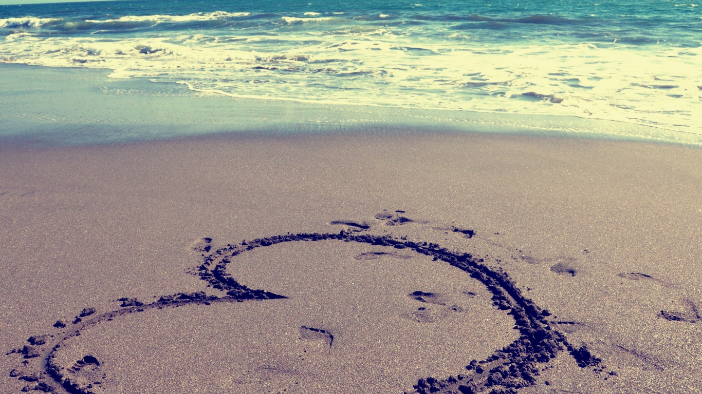 Большое сердце на мокром песке на пляже