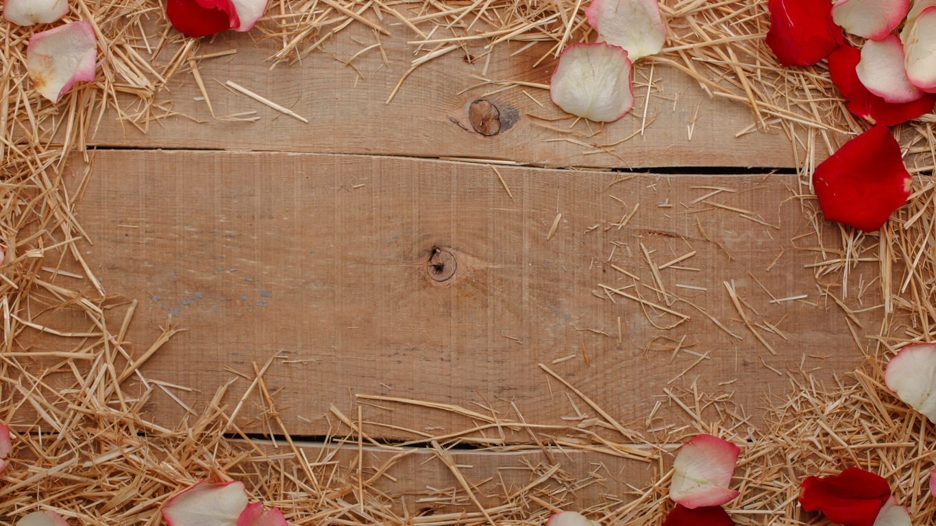 Сено и лепестки роз на деревянном столе 