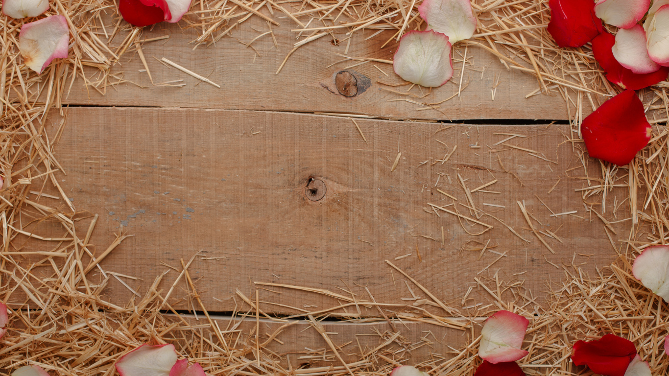 Сено и лепестки роз на деревянном столе 