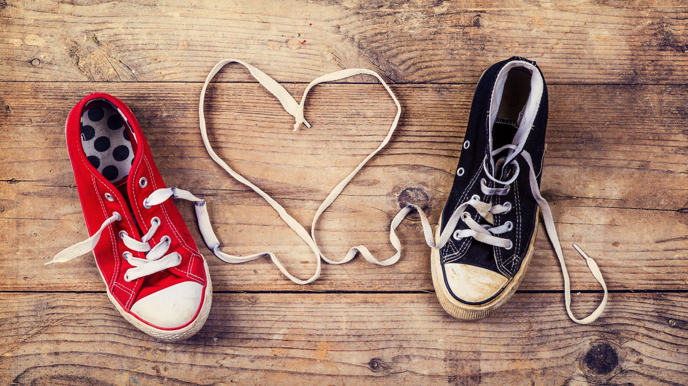 Сердце из шнурков кед на деревянном столе 