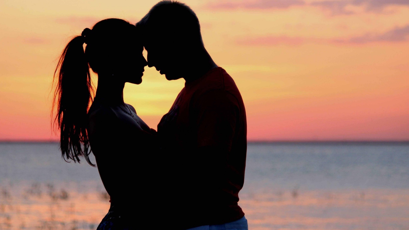 Влюбленная пара на фоне моря в сумерках 