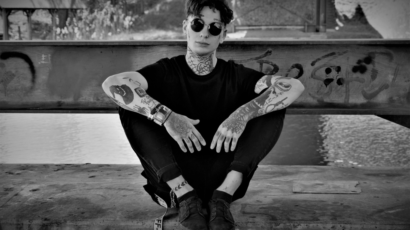 Мужчина в черных очках с татуировками на теле 