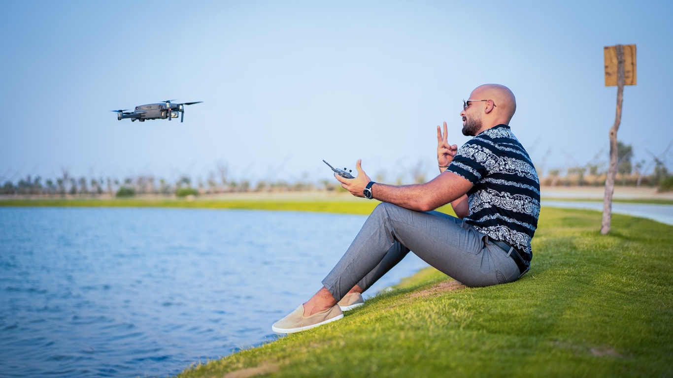 A man launches a quadrocopter over the lake