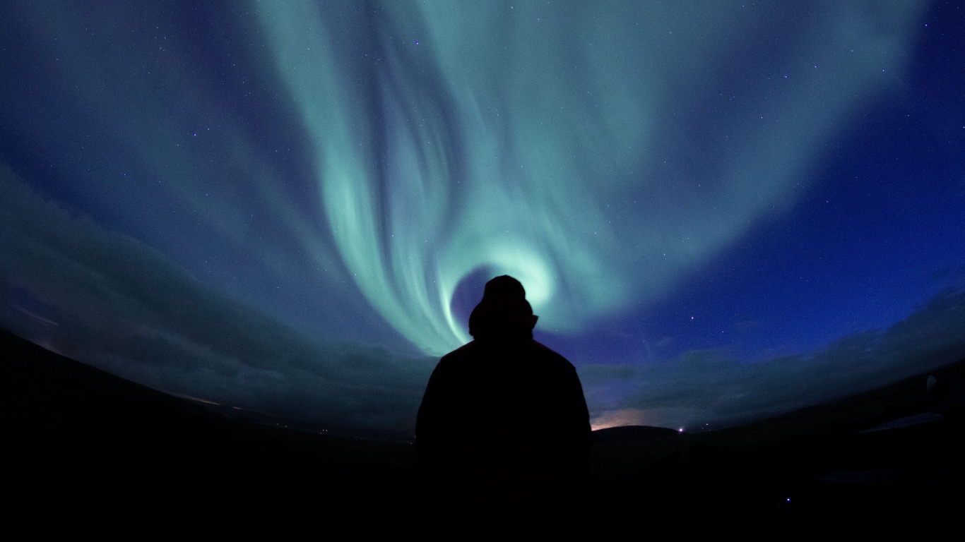 Silhouette of a man on a background of the sky with aurora