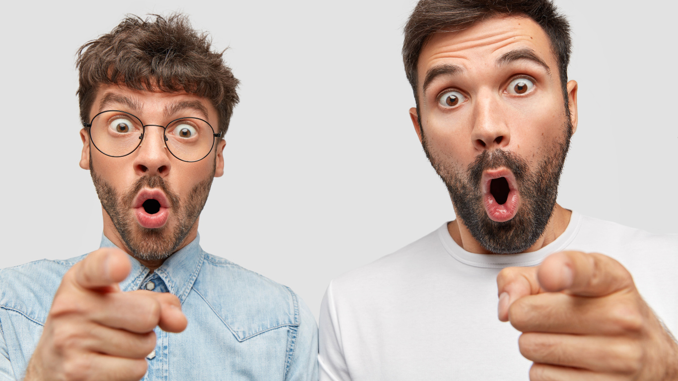 Два удивленных мужчины на сером фоне