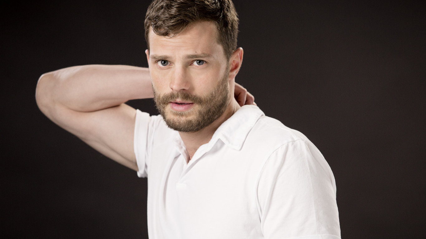 Актер Джейми Дорнан в белой рубашке на коричневом фоне