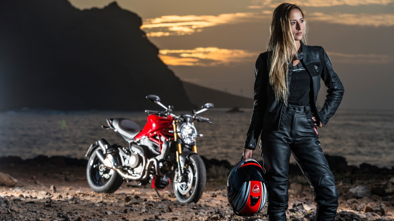 Молодая блондинка в кожаном костюме на мотоцикле