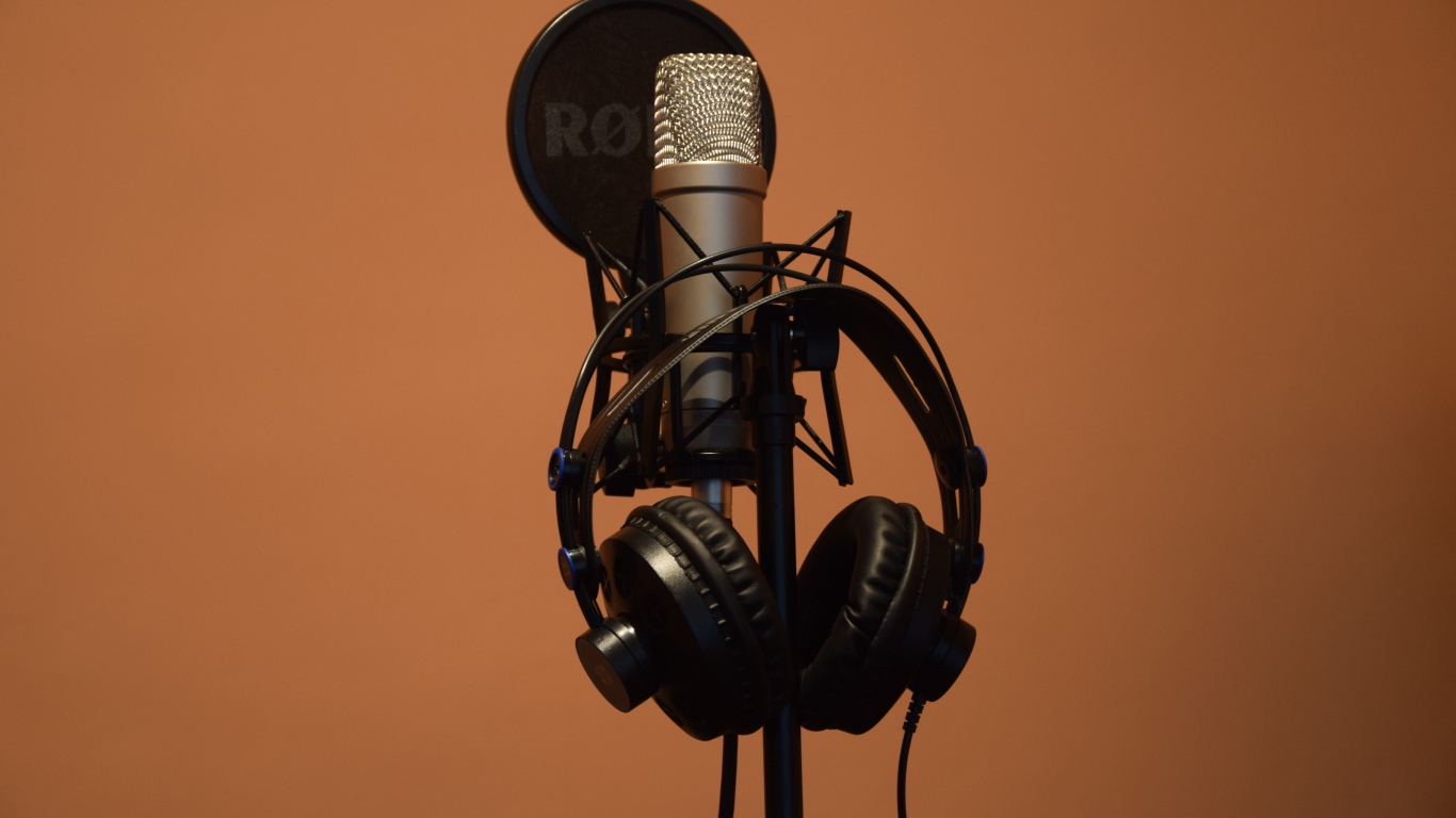 Конденсаторный микрофон с наушниками на коричневом фоне