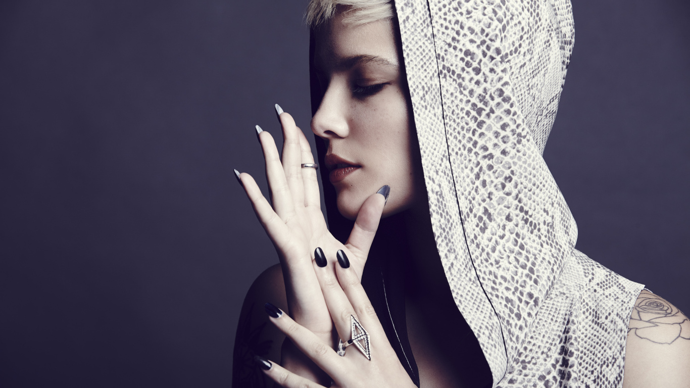 Певица Холзи в капюшоне на сером фоне