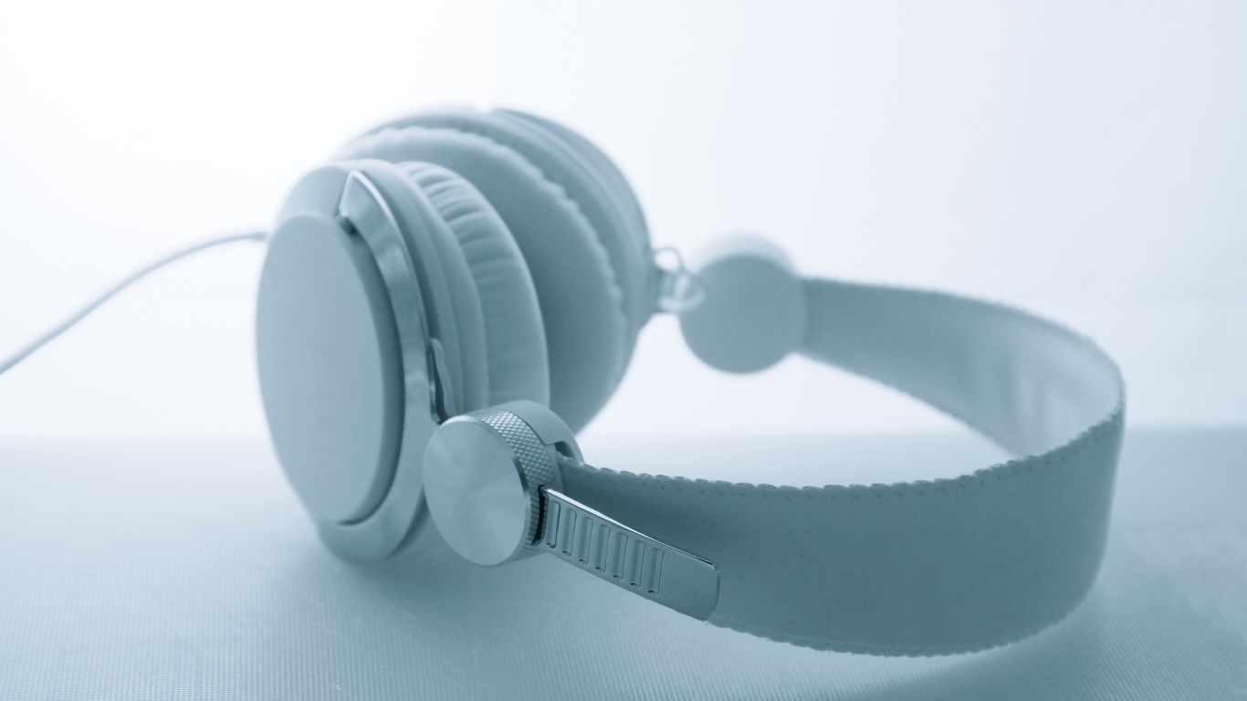 Белые большие наушники лежат на белом фоне