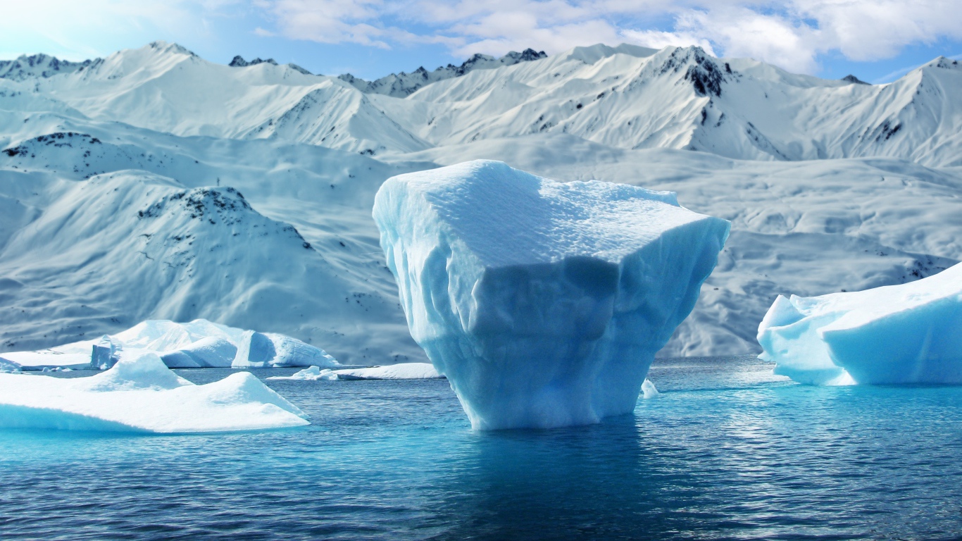 Large blocks of ice in the water against the background of snow-capped mountains