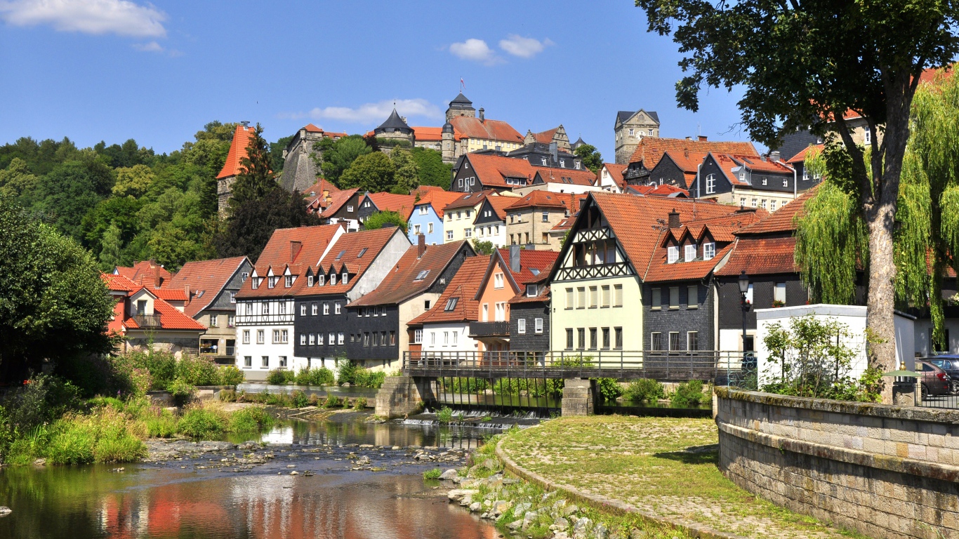 Много домов у пруда на фоне голубого неба