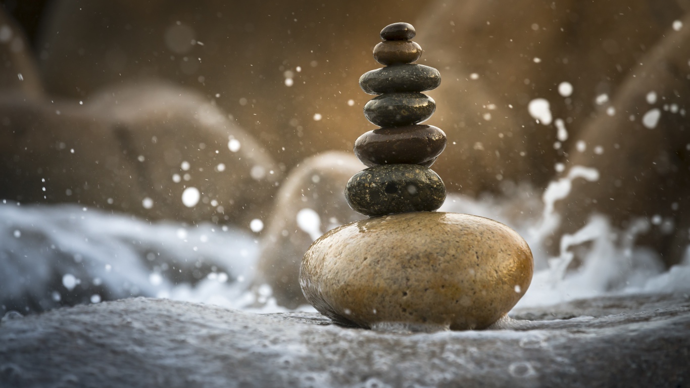 Гладкие мокрые камни в белой морской пене 