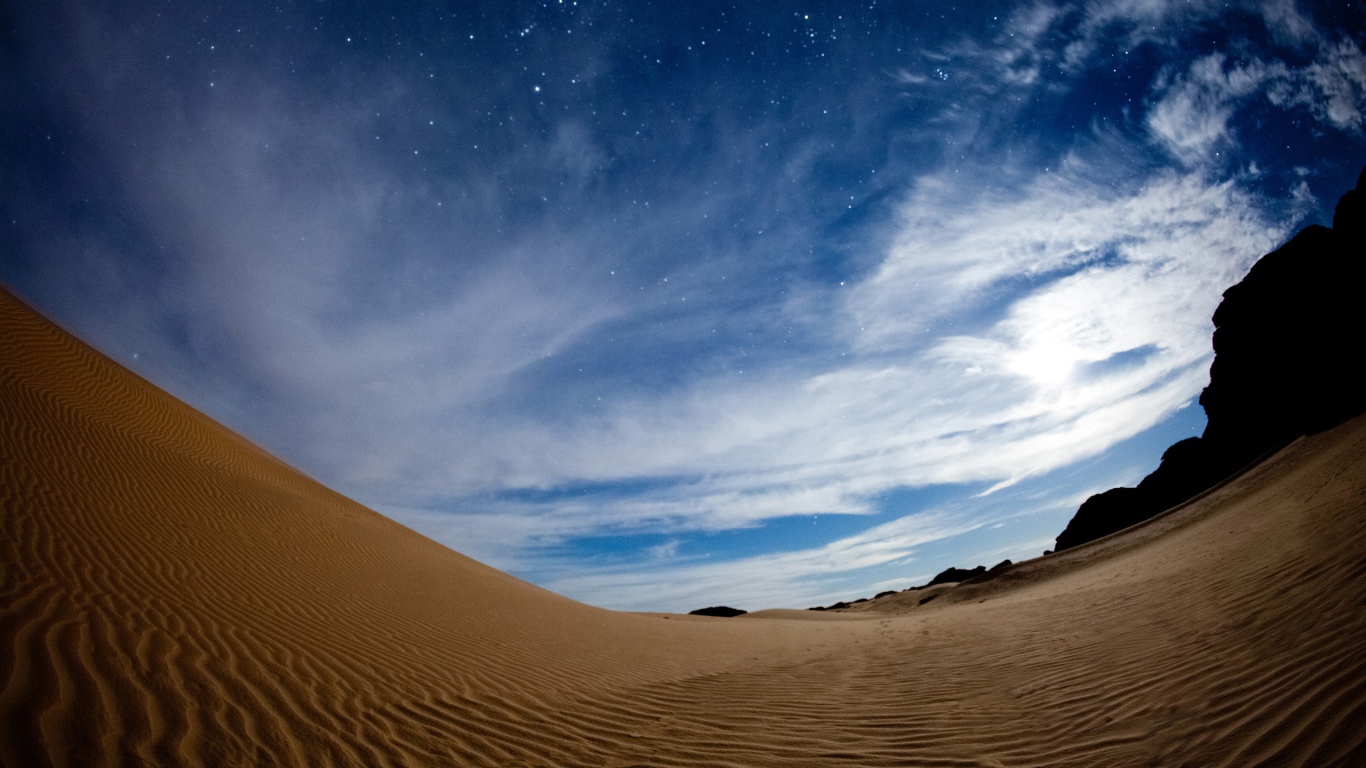 Волнистая песчаная дюна под красивым небом в сумерках 