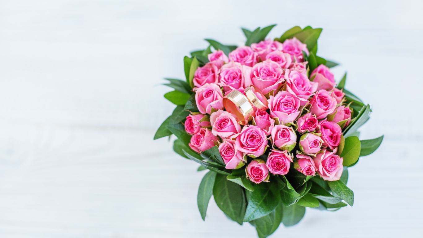 Большой букет розовых роз с золотыми обручальными кольцами