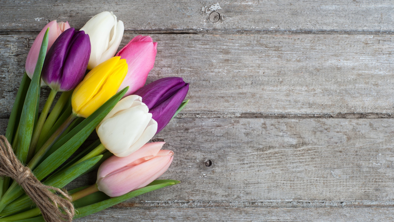 Букет разноцветных тюльпанов на деревянном столе