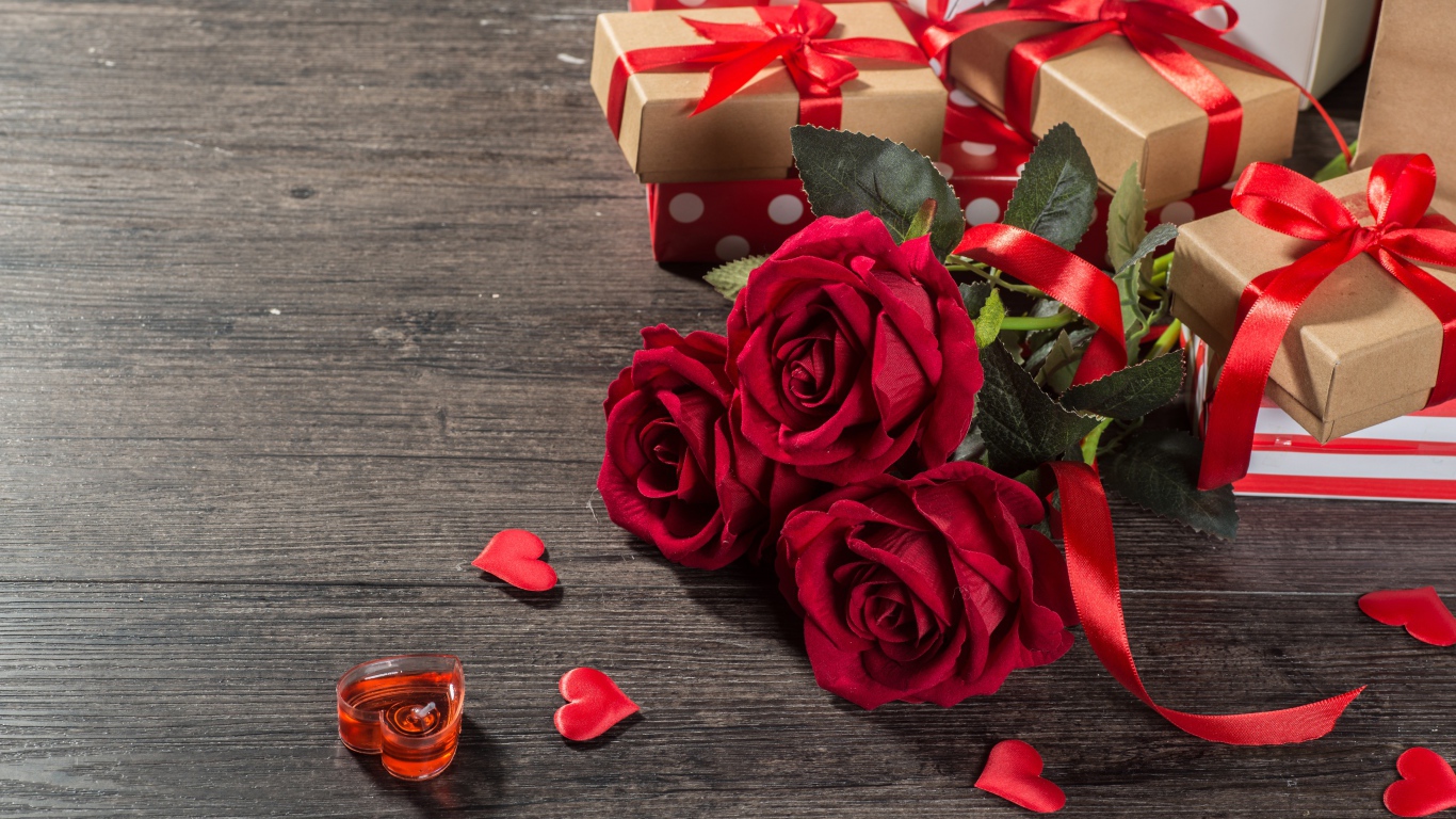Букет красных роз и подарки на столе 