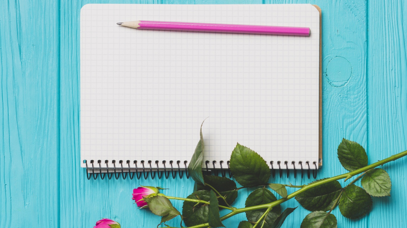 Ветка с розами на голубом фоне с блокнотом и карандашом