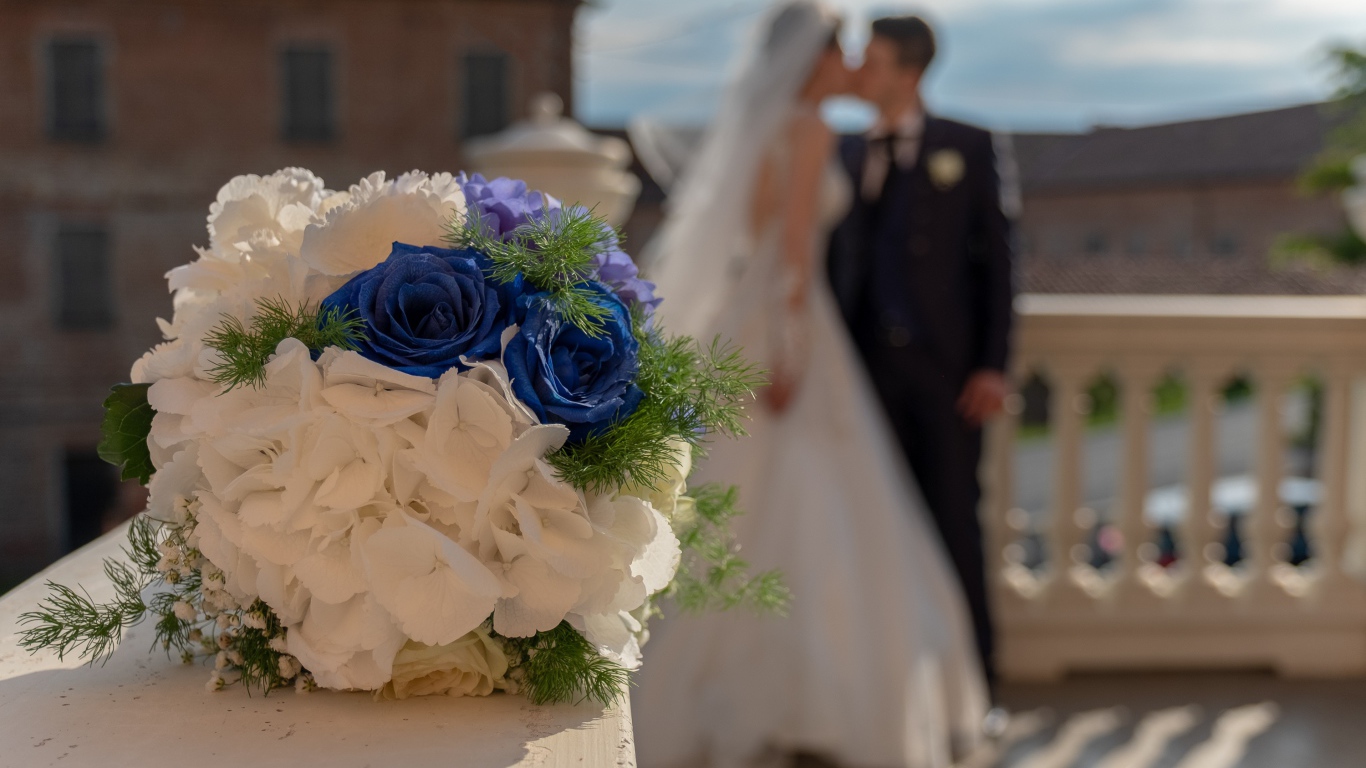 Свадебный букет на фоне новобрачной пары 