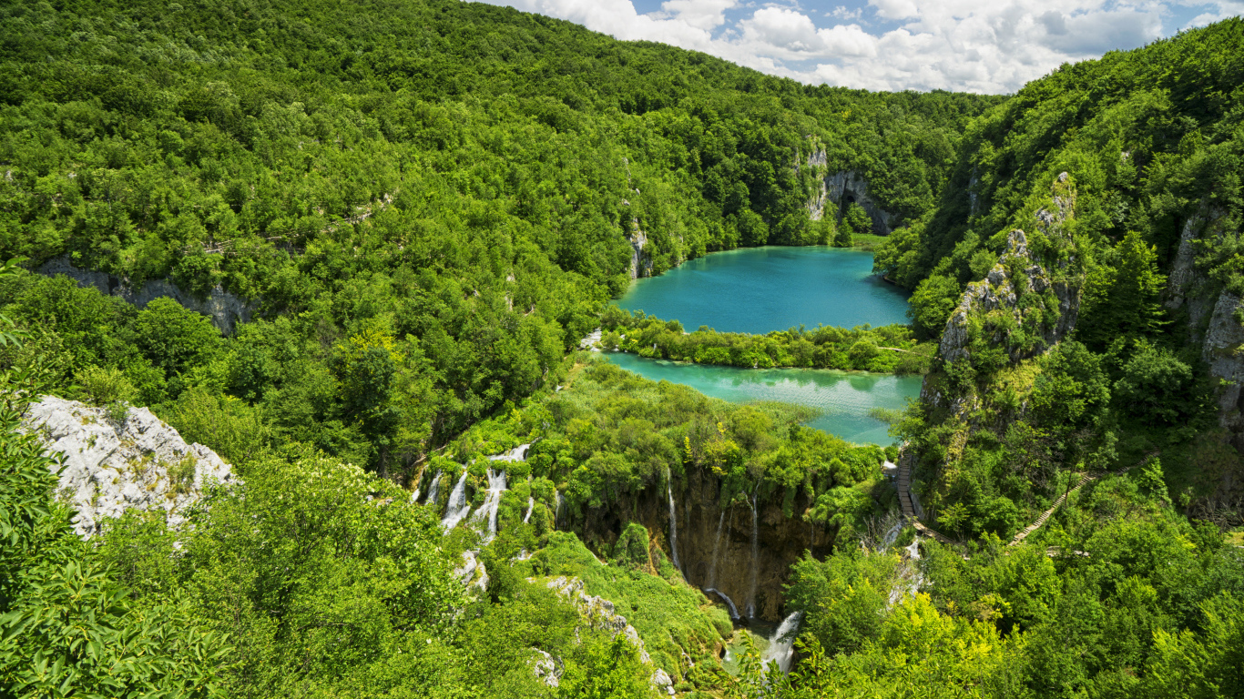 Голубая вода в озере у покрытых деревьями гор 