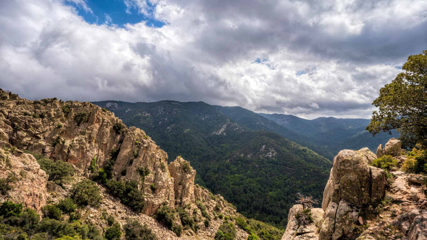 Зеленые вершины гор под белыми облаками 