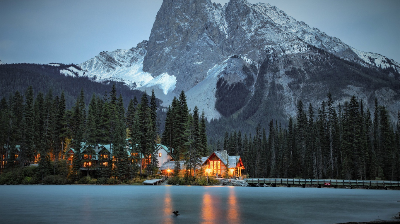 Высокая гора у озера с хвойным лесом