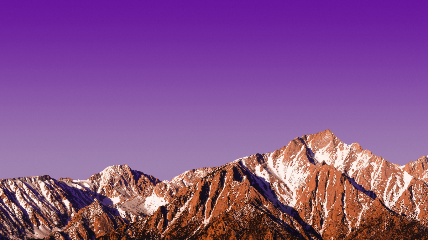 Вершины заснеженных гор на фоне сиреневого заката