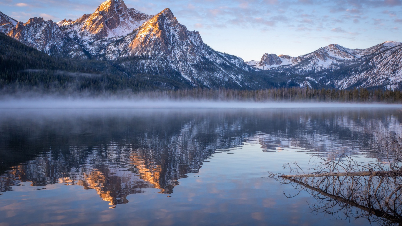 Туман над холодным озером на фоне гор 