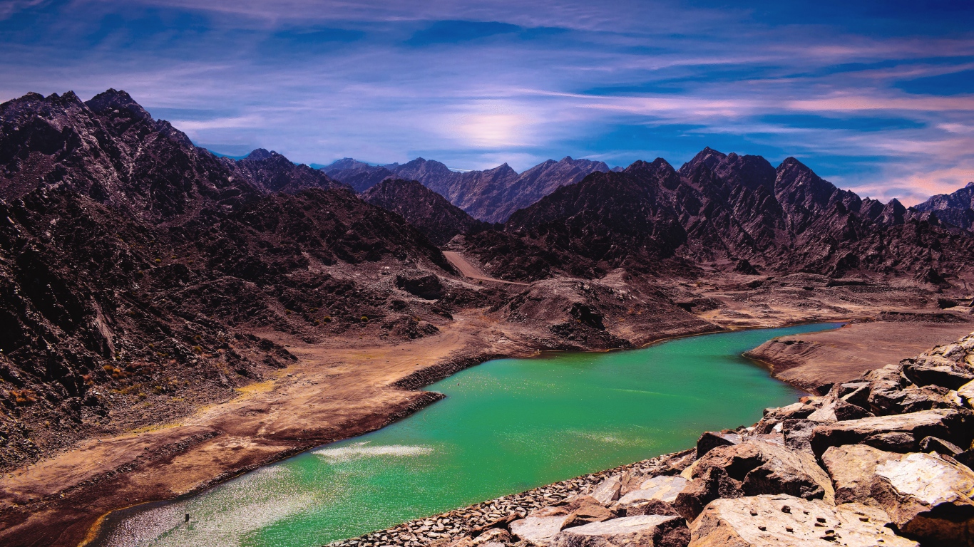 Река между высоких гор под голубым небом 