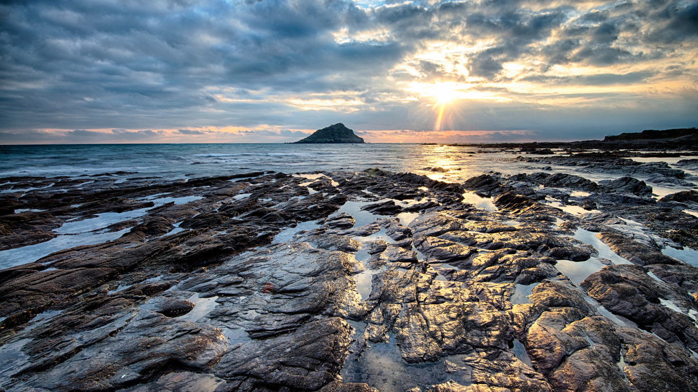Каменный берег океана в лучах солнца