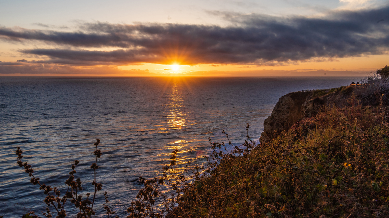 Вид на закат солнца в темных облаках в небе над морем 