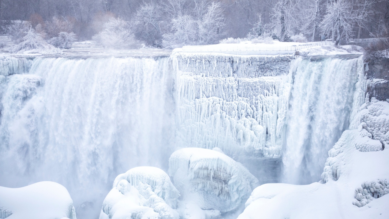 Замерзший водопад стекает по камням зимой