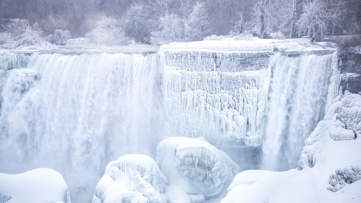 Замерзший водопад стекает по камням зимой