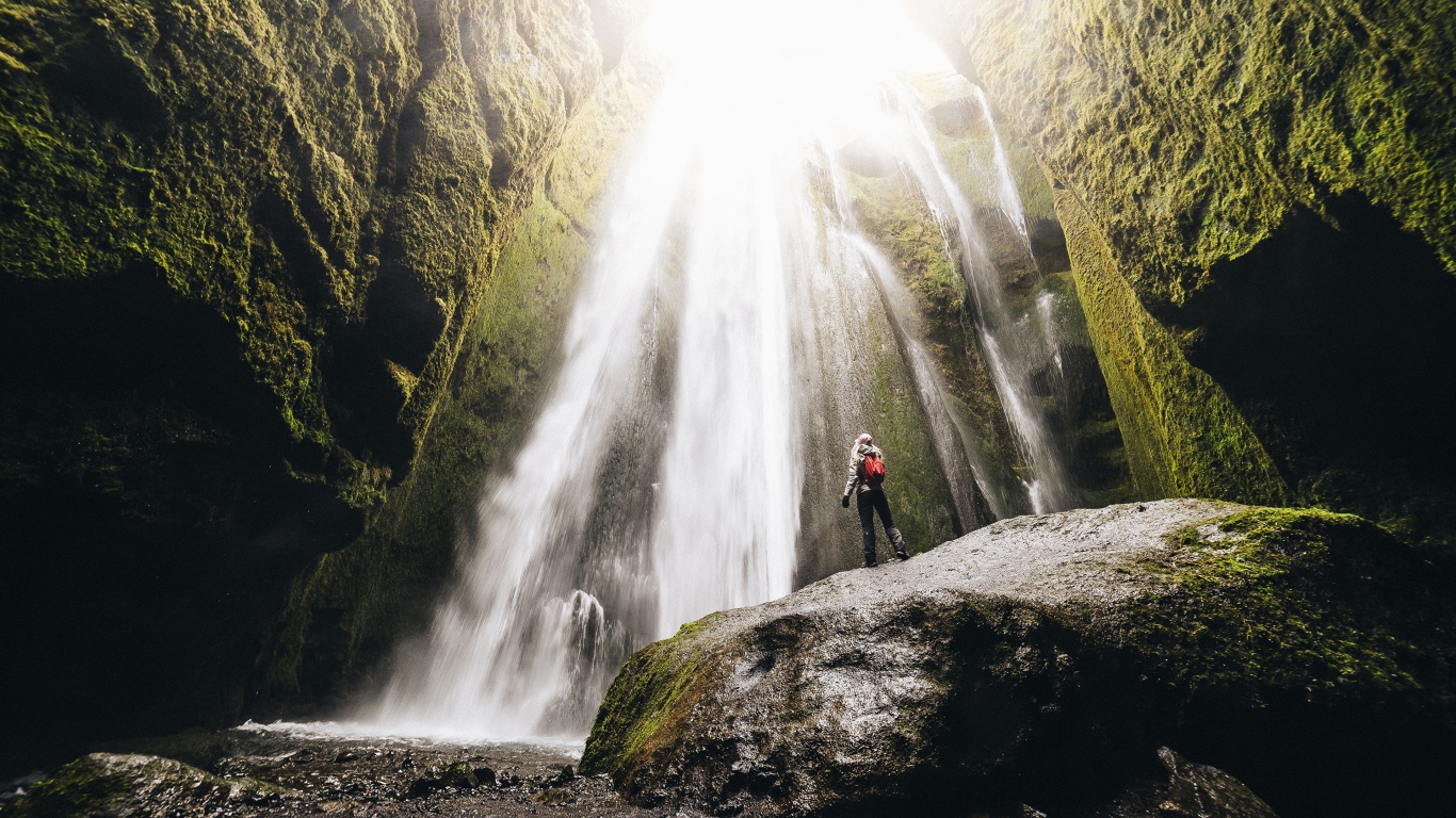 Быстрый водопад стекает между скал 