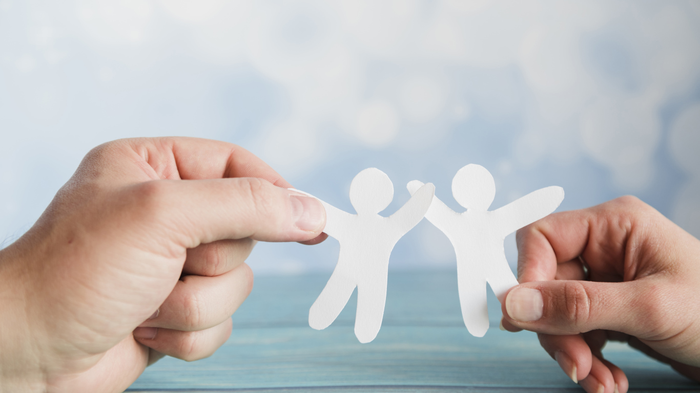 Два бумажных человечка в руках 